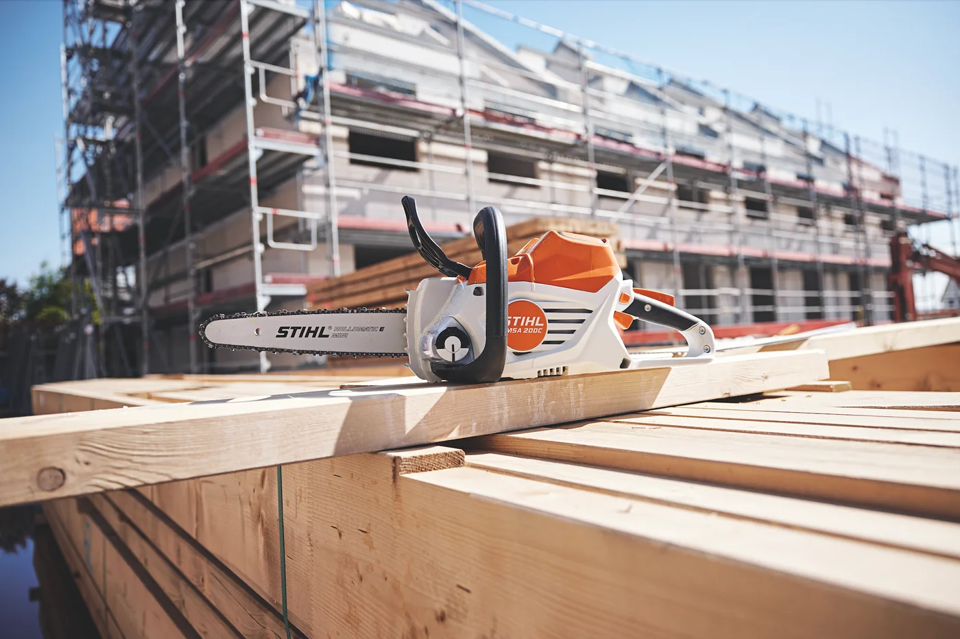 STIHL MSA 200 C-B batterimotorsag liggende på trevirke, pressefoto fra 2022.
